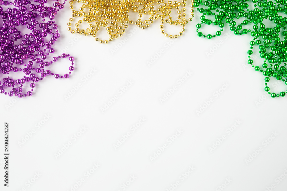 Mardi gras background on white with purple gold green beads and copy space - obrazy, fototapety, plakaty 