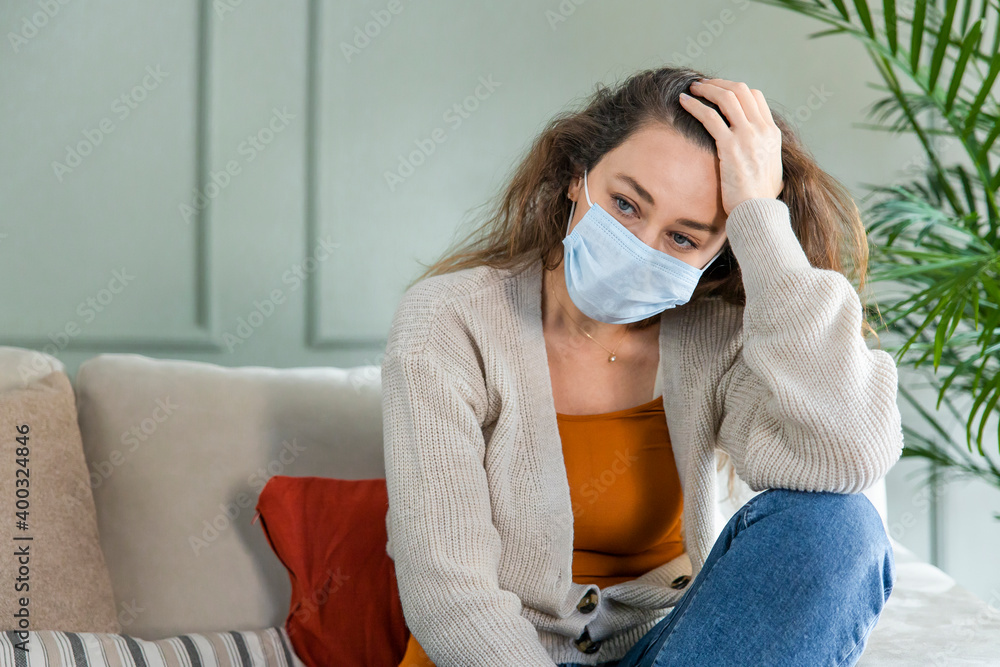 Sad young woman isolated stay at home in protective sterile mask on her face