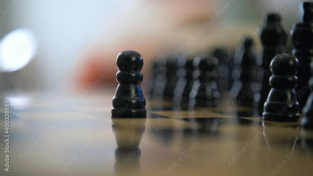 Two players move black and white pawn wooden chess pieces on checkerboard close Two players move black and white pawn wooden chess pieces on checkerboard close