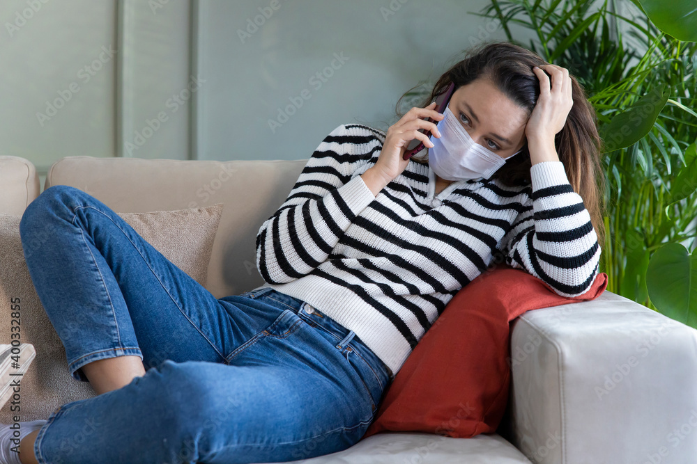 Obraz premium Young woman wearing protective face mask talking on the phone.