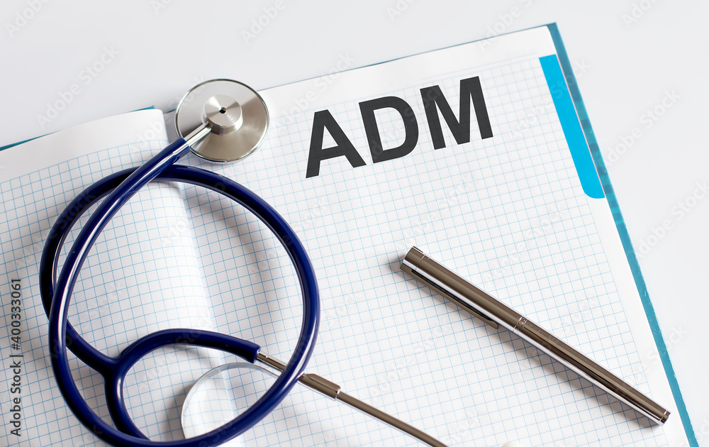 Paper with text ADM on table with stethoscope Paper with text ADM on table with stethoscope