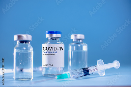 Covid19 Vaccine syringes and medicine bottles in blue environment