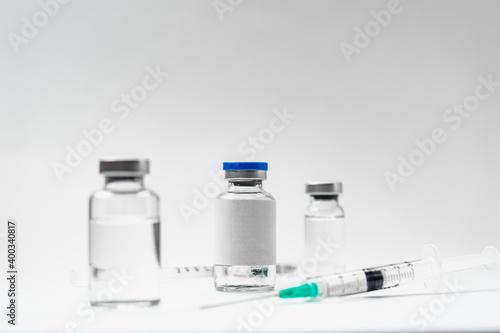 Medical treatment syringes and vaccine bottles in white environment 
