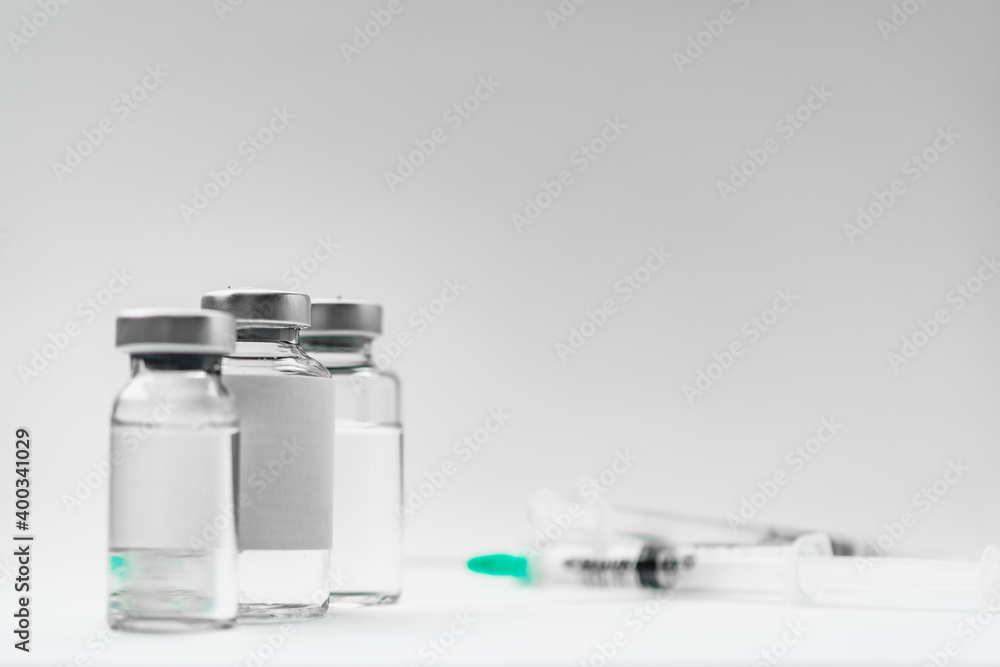 Medical treatment syringes and vaccine bottles in white environment Medical treatment syringes and vaccine bottles in white environment