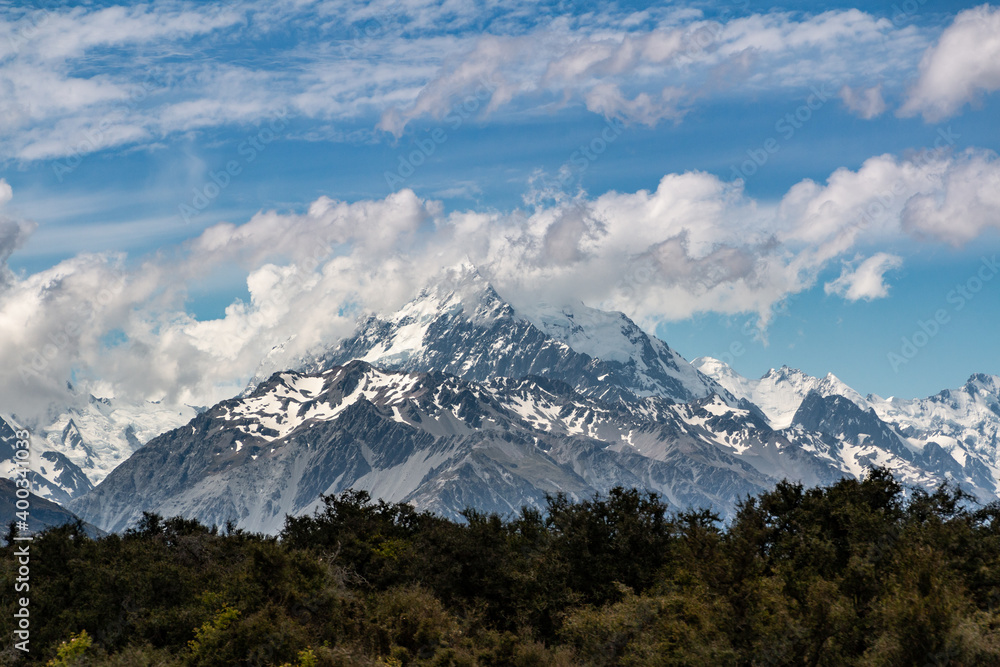 Fototapeta premium snow top mountain behind a forest