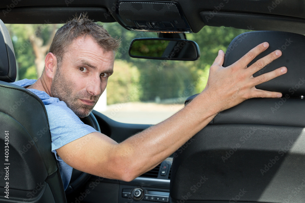 man looking over his shoulder while reversing man looking over his shoulder while reversing