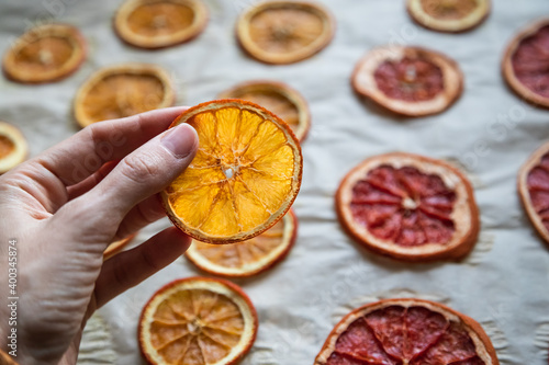 dried orange slice in a hand for diy projects, gift wrapping and beautiful eco Christmas decorations like wreaths