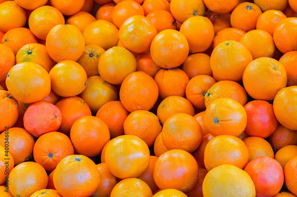 Bright background with a lot of round orange tangerines