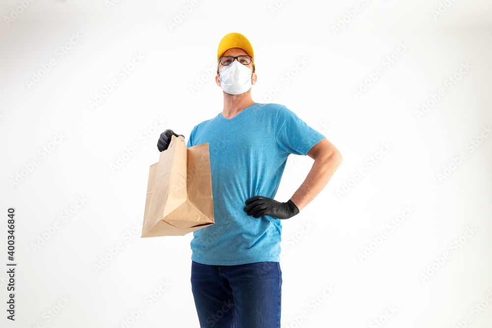 Delivery guy with protective mask holding paper bag with groceries. Delivery guy with protective mask holding paper bag with groceries.