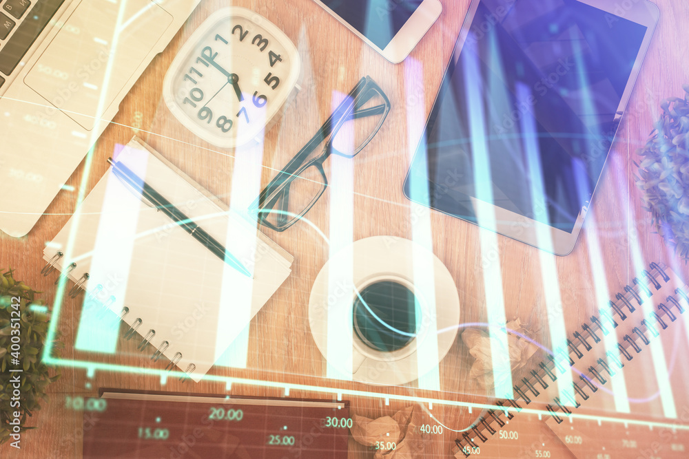 Double exposure of financial chart hologram over desktop with phone. Top view. Mobile trade platform concept. Double exposure of financial chart hologram over desktop with phone. Top view. Mobile trade platform concept.