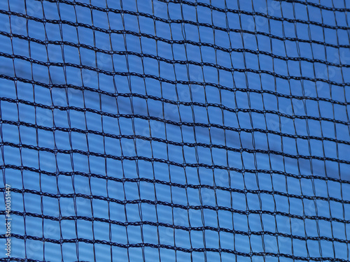 metal net of a playing field with clear blue sky in the background