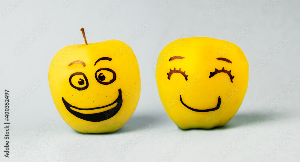 different emotions of joy, smile and happiness Face on an apple - abstract image of human emotions on blue background different emotions of joy, smile and happiness Face on an apple - abstract image of human emotions on blue background