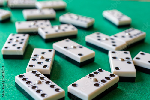 Top view of domino pieces  with selective focus  on green baize  horizontal