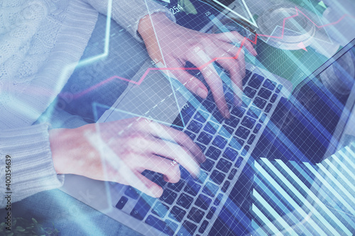 Double exposure of woman hands typing on computer and forex chart hologram drawing. Stock market invest concept.