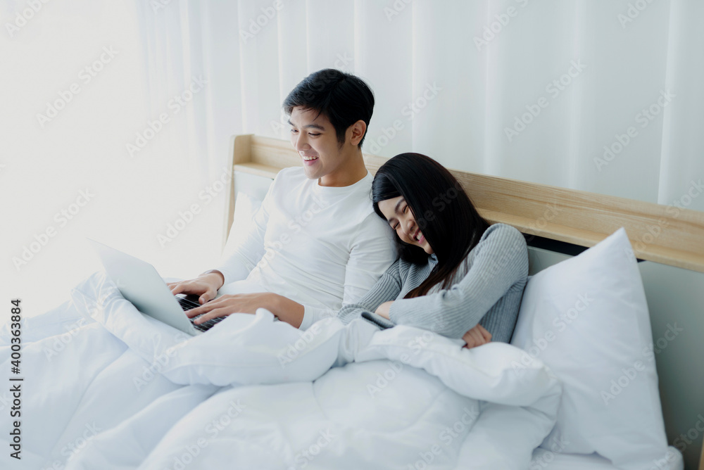 Fototapeta premium Asian couples rest and relax in bed.