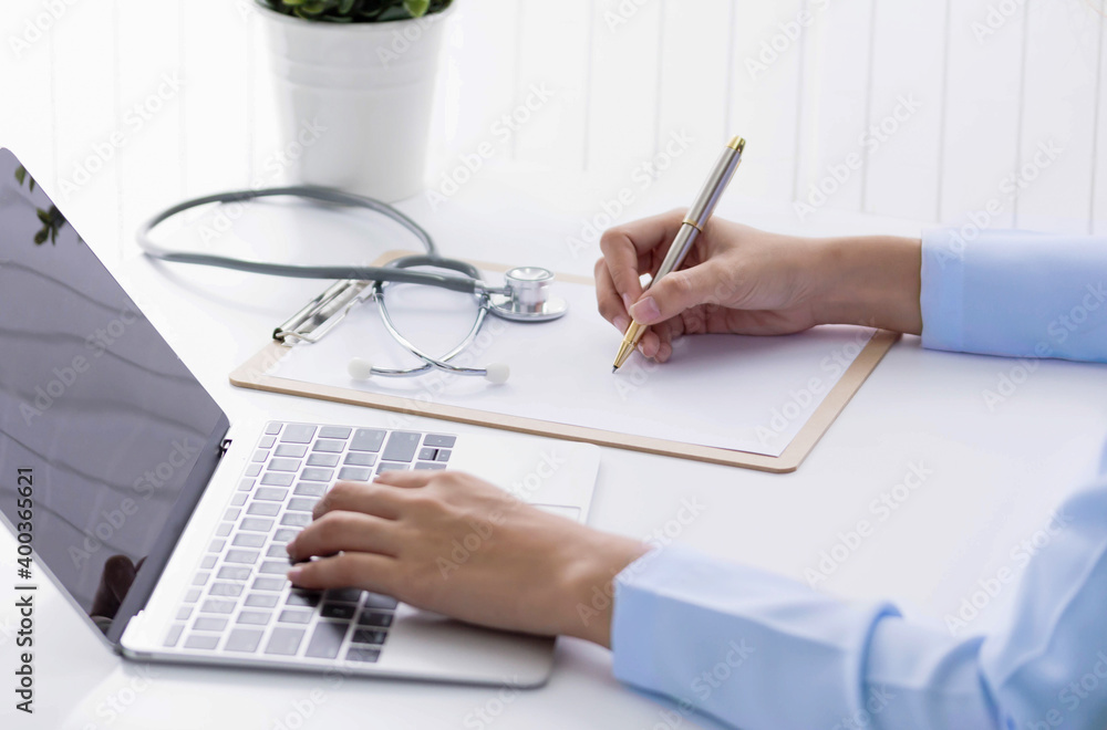 doctor working on office write report with medical stethoscope use laptop . Health care concept.telemedicine or teleconference, electronics doctor working on office write report with medical stethoscope use laptop . Health care concept.telemedicine or teleconference, electronics