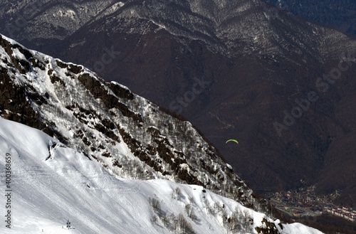 Winter landscape with mountain peaks, gorges, deep snow cover, ski slopes.