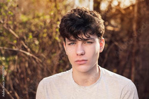Upset young teenager rests in nature and spends his free time thinking about the future, thinking about who to become, who to study. The boy is sad because he has a headache