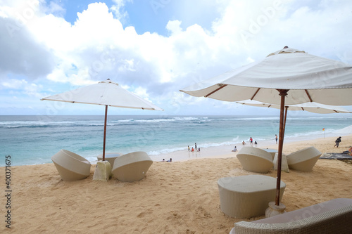 Melasti beach is stunning and blue sea water and umbrella chairs to rest photo