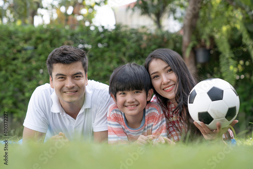 Happy family relaxes in the front lawn on a weekend together.