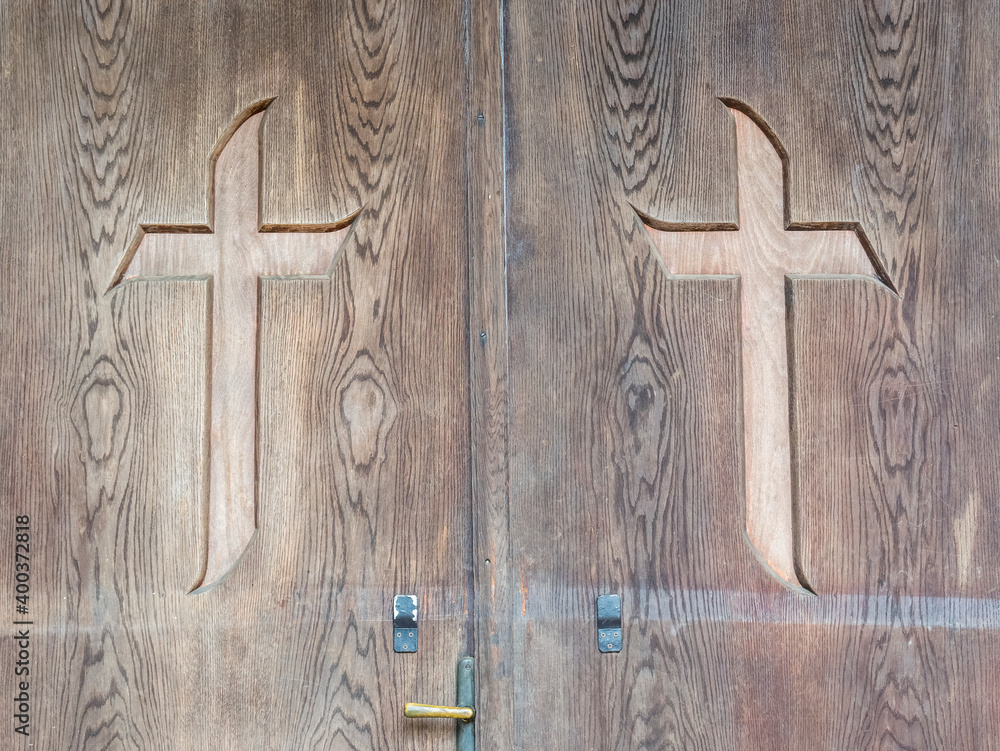 Christian cross carved in a wooden door