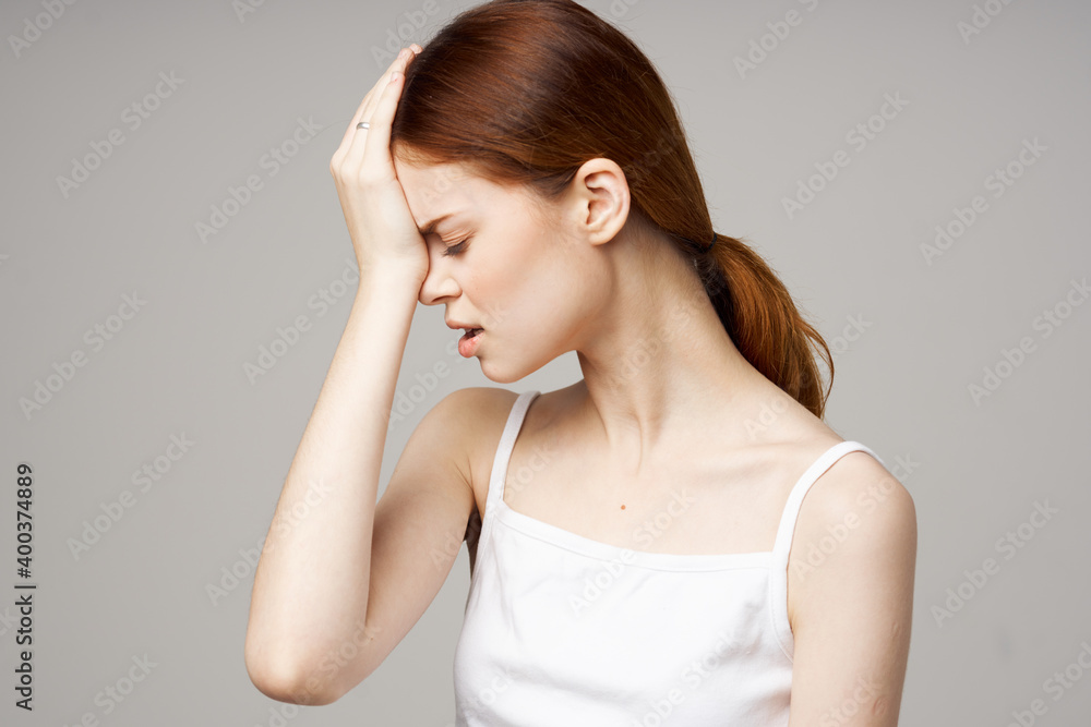headache woman in white t-shirt touching face with hands health problems