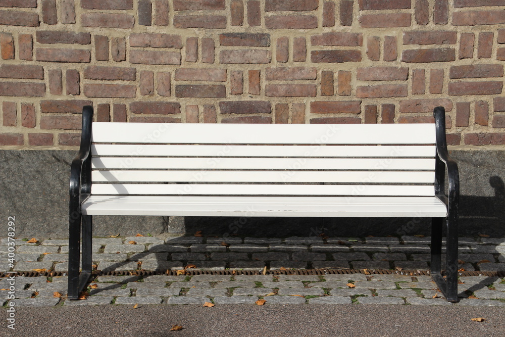 White bench on the background of brick wall White bench on the background of brick wall