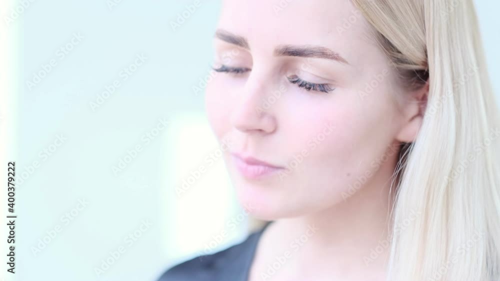 Beautiful young woman with delicate rose flower. Girl clean fresh skin touching her face in flowers. Slow motion video. stock footage Beautiful young woman with delicate rose flower. Girl clean fresh skin touching her face in flowers. Slow motion video. stock footage