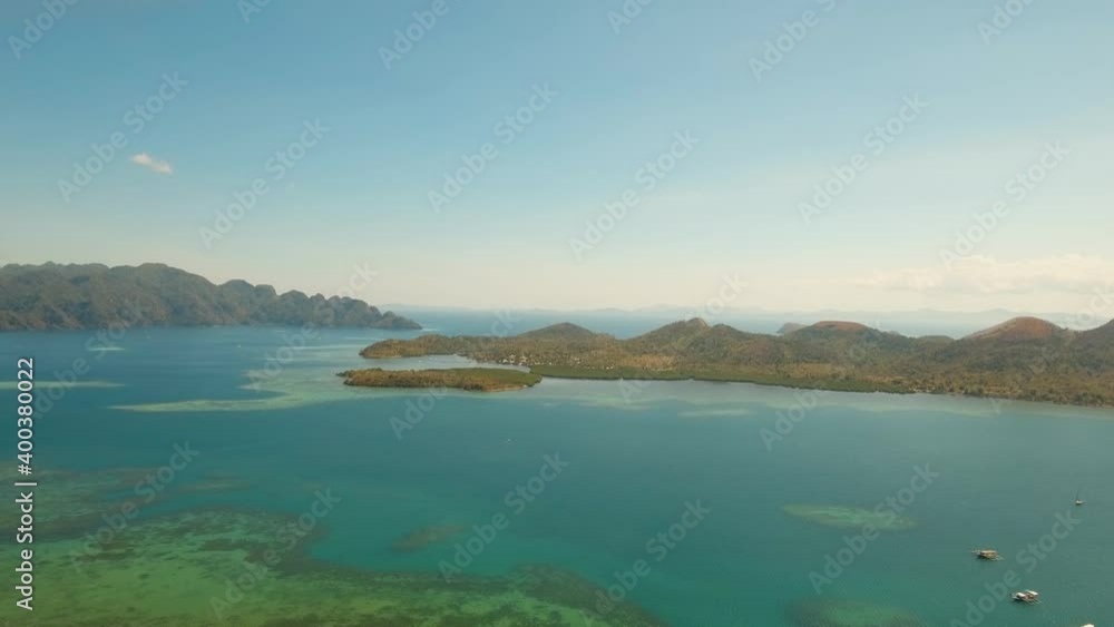 aerial island with mountains in lagoon with turquoise water and coral reef. Busuanga, Palawan. Flying over the azure surface ocean. Seascape, tropical landscape. Travel concept aerial island with mountains in lagoon with turquoise water and coral reef. Busuanga, Palawan. Flying over the azure surface ocean. Seascape, tropical landscape. Travel concept