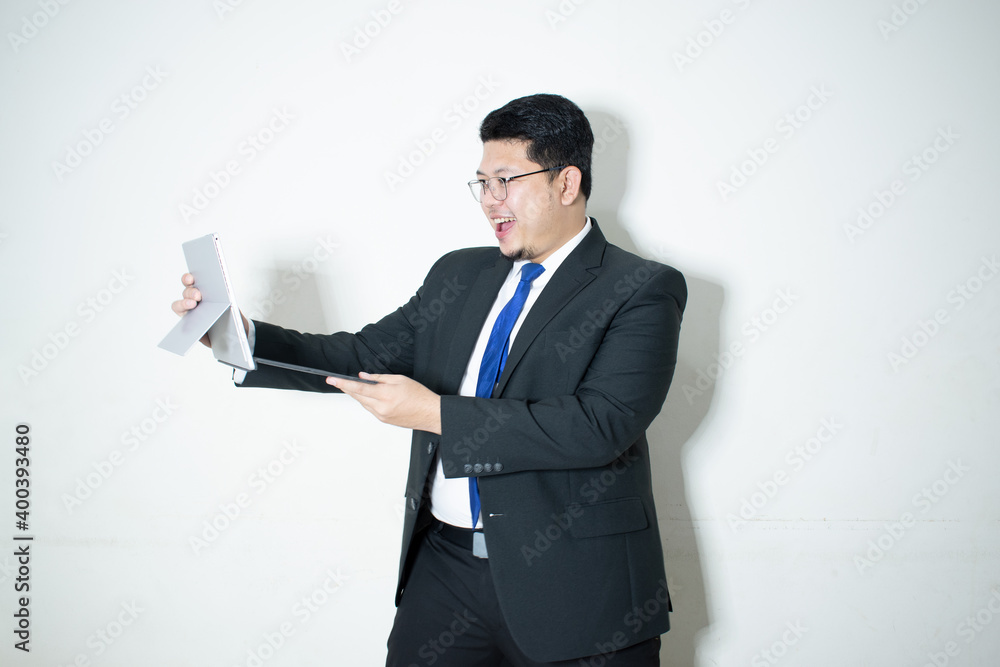 Happy young business man working on a laptop, isolated on white background Happy young business man working on a laptop, isolated on white background