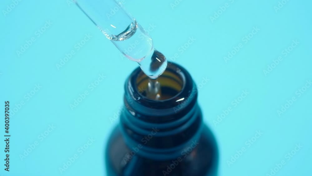 Drop falls from a pipette into a cosmetic bottle Drop falls from a pipette into a cosmetic bottle