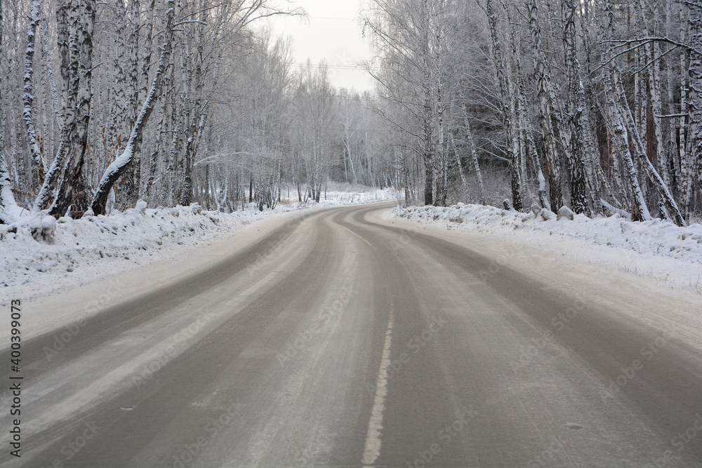 Snow-covered road in a snow-covered pine forest Snow-covered road in a snow-covered pine forest