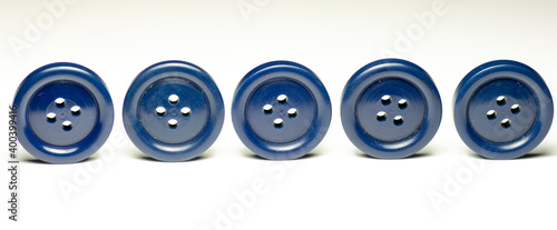 Group of blue round plastic buttons isolated on white background. Close up. Macro.