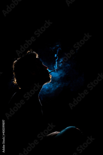 Colored silhouette of a smoking man on dark background. © ErdalIslak