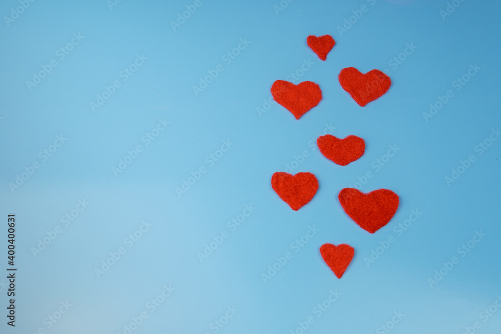 Cut out red hearts on a blue background.