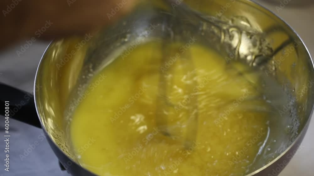 Chef whips yellow sauce with a whisk Chef whips yellow sauce with a whisk
