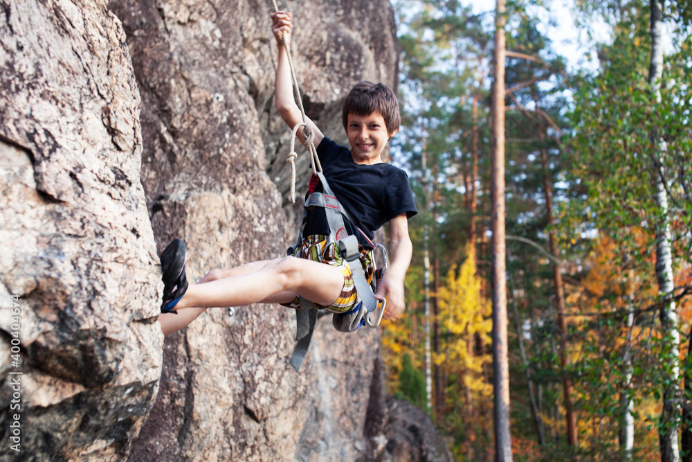 cute teen kid climbing on rock with insurance, lifestyle sport people concept cute teen kid climbing on rock with insurance, lifestyle sport people concept