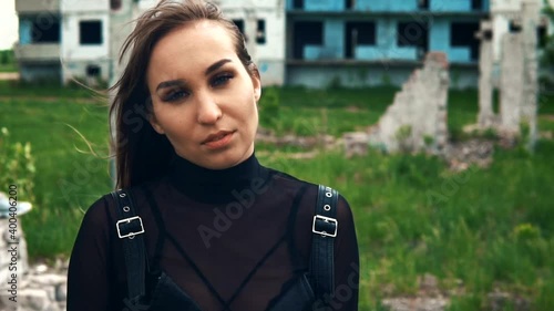 Girl on the background of an abandoned building. Hair fluttering in the wind. Slow motion photo