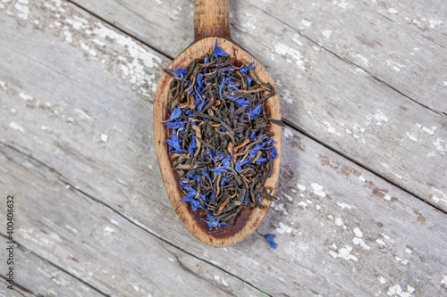 Loose Earl Grey tea leaves on a vintage wooden spoon and table with space for text