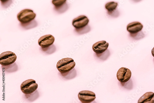 Medium roast Arabica coffee beans on pink background