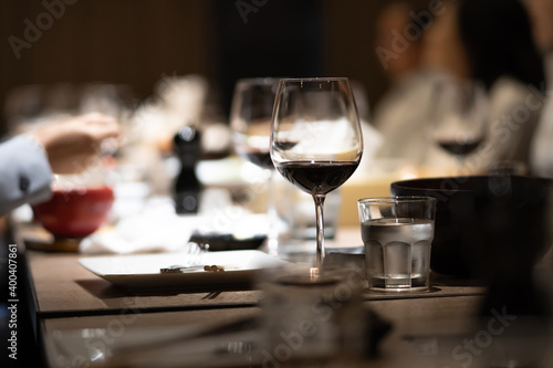 A glass of red wine is placed on the dining table in a fine dining restaurant