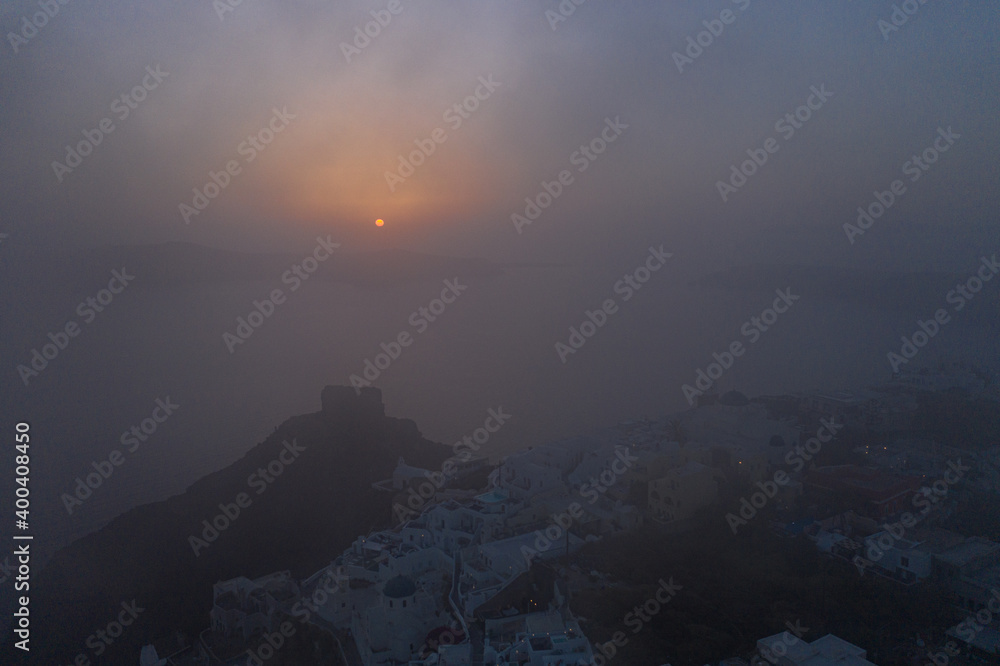 imerovigli sunset cloudy, Santorini island with colorful volcanic cliffs and deep blue sea aerial view