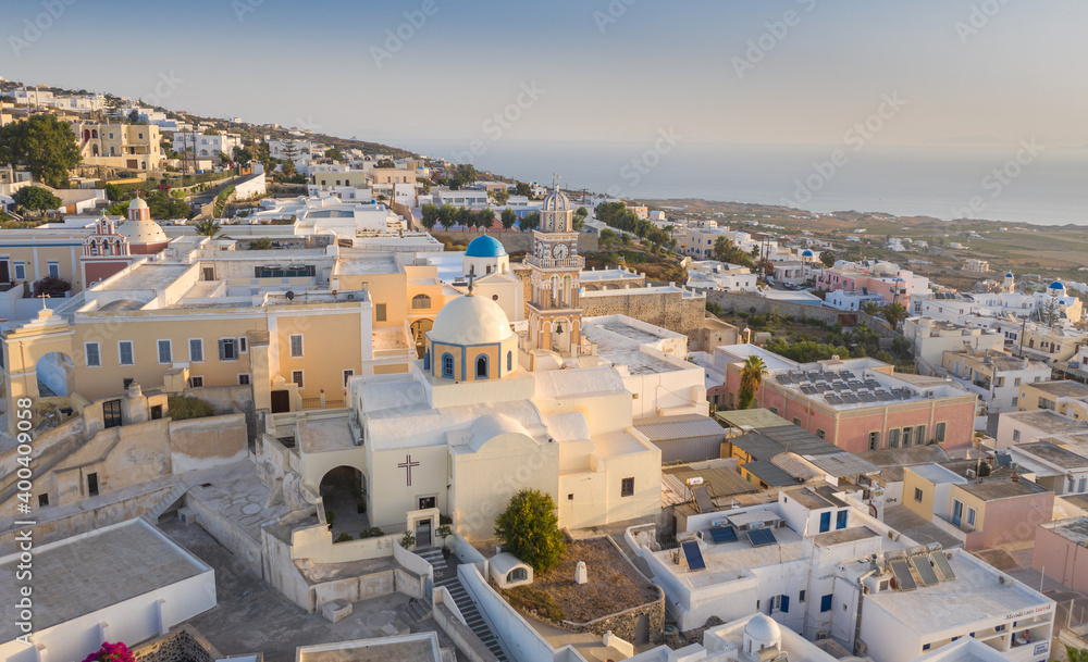 Fototapeta premium Oia town on Thira. Santorini island with colorful volcanic cliffs and deep blue sea aerial view