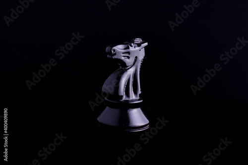 one side light on Black knight chess piece in black background
