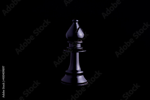 Tablou canvas one side light on Black bishop chess piece in black background