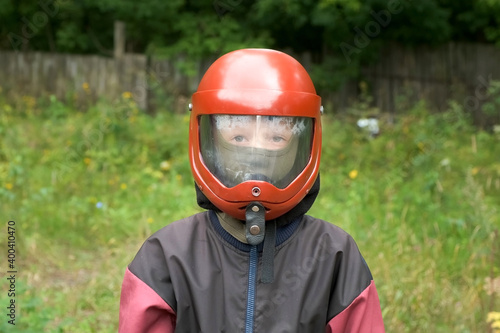 Portrait of child boy in costume and helmet to flying in aerodynamic tube. Entertainment in the fresh air, flying in aerodynamic tube. Outdoors activity. © familylifestyle