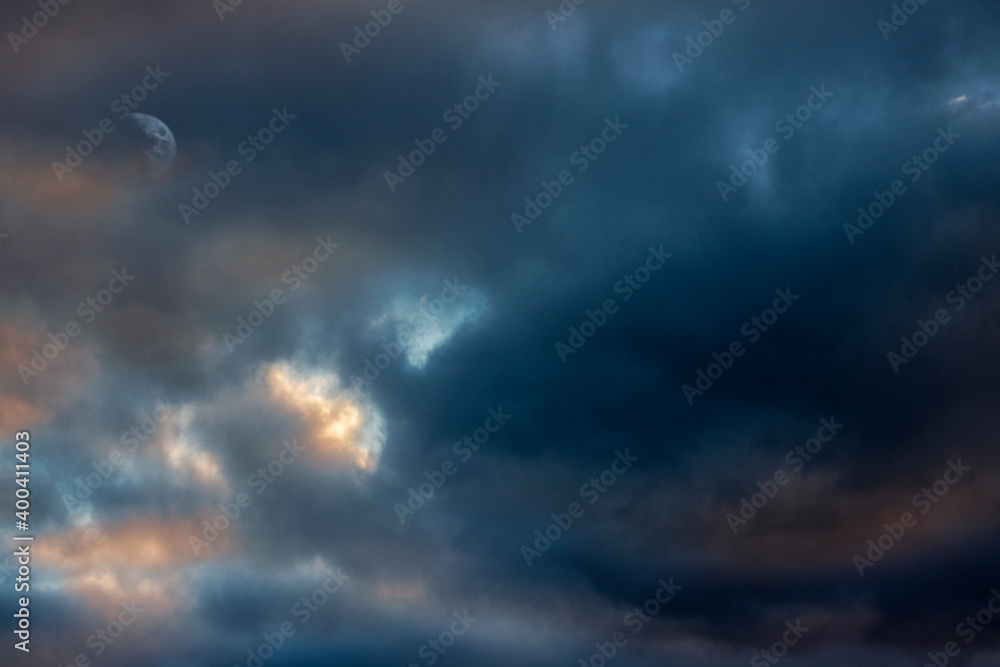 Mottled dark sunset sky with moon barely showing Mottled dark sunset sky with moon barely showing