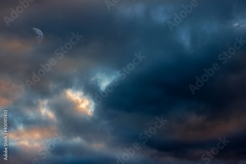Mottled dark sunset sky with moon barely showing