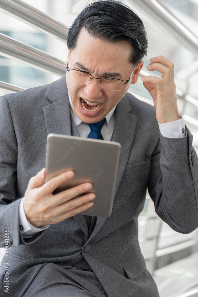 business man is stressed from work ,tablet phone computer in hand - lifestyle business people concept business man is stressed from work ,tablet phone computer in hand - lifestyle business people concept