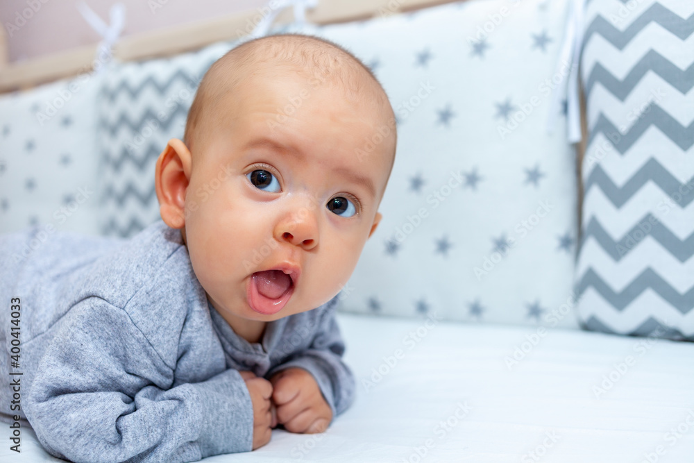 The newborn lies on his stomach and holds his head The newborn lies on his stomach and holds his head